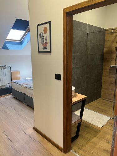 a bathroom with a shower and a bedroom with a bed at Rooms Lišnić in Osijek
