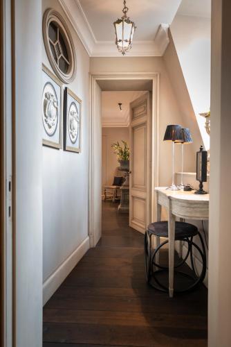 a hallway with a table and a lamp on a table at Cobergher Hotel in Kortrijk