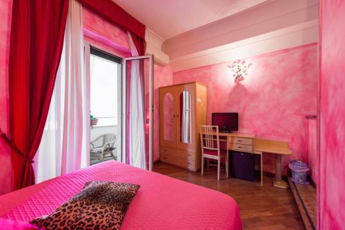 a pink bedroom with a desk and a bed at Rifugio Di Roma in Rome