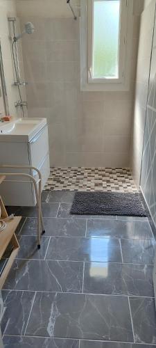 La salle de bains est pourvue d'un lavabo et de carrelage. dans l'établissement Maison avec Piscine Tour de France le 11 et 12 Juillet, à Villeneuve-sur-Lot