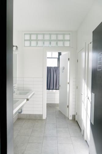 a white bathroom with a sink and a toilet at Saintlo Ottawa Jail Hostel in Ottawa