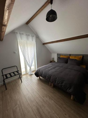 une chambre avec un grand lit et une fenêtre dans l'établissement Au 112 maison d'hôtes, à Estrées-Saint-Denis