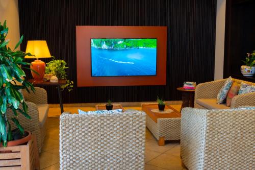 a living room with two chairs and a flat screen tv at Hotel Garden in Praia a Mare