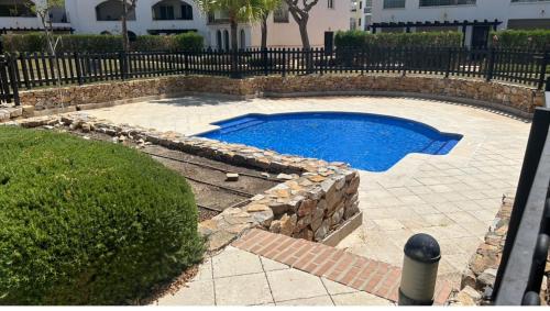 a small swimming pool with a stone wall around it at Planta baja en La Torre Golf in Torre-Pacheco