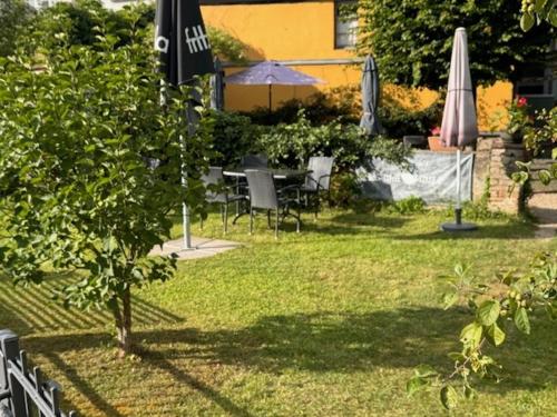 a garden with a table and chairs and an umbrella at Apartment Diez in Diez
