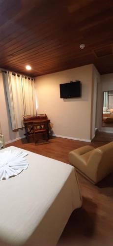a bedroom with a bed and a flat screen tv at Skalla Hotel Nova Odessa in Nova Odessa