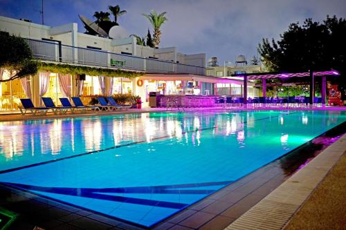 a large swimming pool with blue water at night at Green Bungalows Hotel Apartments in Ayia Napa