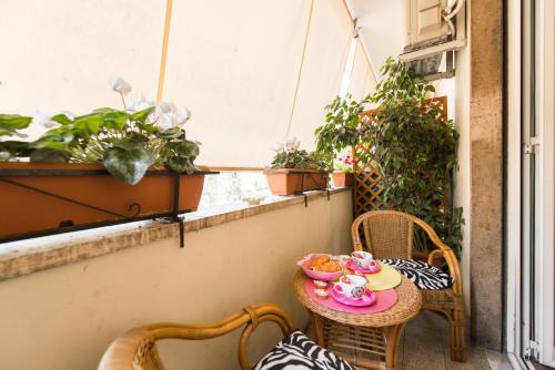 a small balcony with a table and chairs and a window at Rifugio Di Roma in Rome