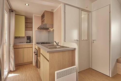 une petite cuisine avec un évier et un réfrigérateur dans l'établissement Mobilhome La Marine, au Grau-du-Roi