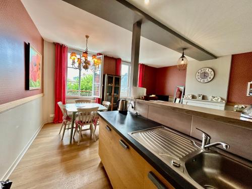 - une cuisine avec un évier et une table dans l'établissement Le Duplex ou l'Appart d'Agnès", à Honfleur