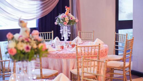 a long table with chairs and flowers in a room at Hotel Colón Plaza Business Class in Nuevo Laredo