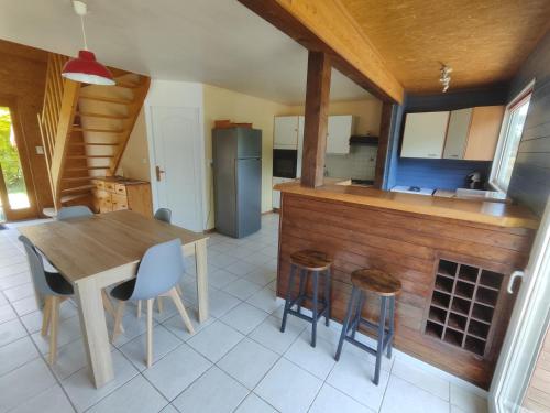 a kitchen with a table and chairs and a refrigerator at Domaine de la roselière • Nature • Brenne in Rosnay