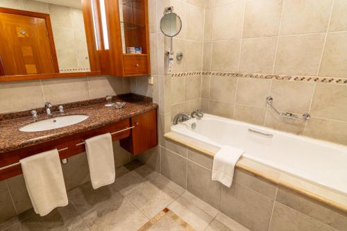 a bathroom with a bath tub and a sink at Park Lake Luxury Hotel in Pucón