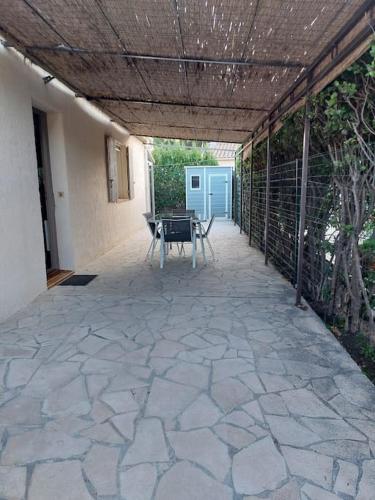 un patio avec une table et des chaises dessus dans l'établissement Au pied des alpilles, à Eyguières