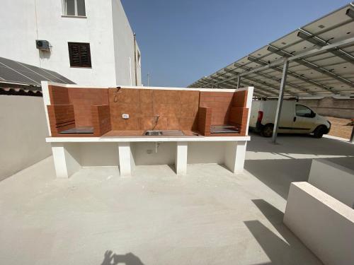 a wooden bench sitting on top of a building at Casa con piscina 2 Camere da letto Profumo Sea & Sun 2A in Triscina