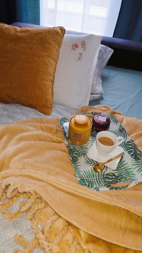 a tray with two cups of coffee and donuts on a bed at Apartmán NAD RIEKOU in Bešeňová
