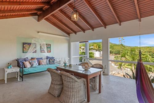 a living room with a bed and a table at Villa San Sebastian Curaçao in Fontein