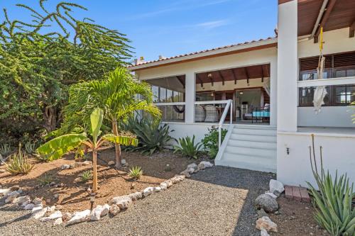 a house with a palm tree in front of it at Villa San Sebastian Curaçao in Fontein