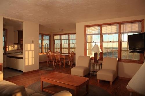 a living room with a kitchen and a table with chairs at Kalmar Village & Tradewinds in North Truro