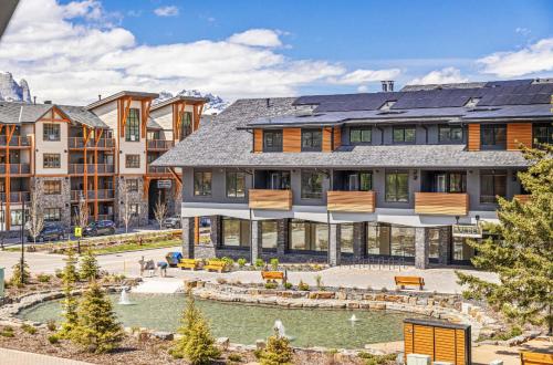 a large house with a pond in front of it at Rundle Lux Villa at Timberstone in Canmore