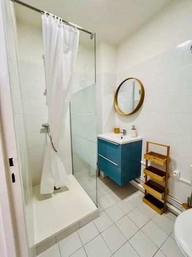 une salle de bain avec une douche, un lavabo et un miroir dans l'établissement L'Escale T2 neuf à 50m de la plage, à Marseille