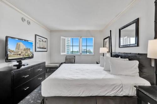 ein Schlafzimmer mit einem großen weißen Bett und einem Flachbildfernseher in der Unterkunft Private Residences at The Atlantic Resort & Spa in Fort Lauderdale