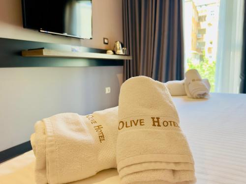 a hotel room with towels on a bed at Hotel Olive in Vlorë