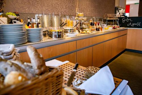 a buffet line in a restaurant with plates and food at Hotel "Zur Mühle" in Hoyerswerda