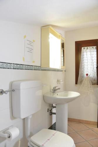 a white bathroom with a toilet and a sink at Saphira by Penta Dream House in Campofelice di Roccella