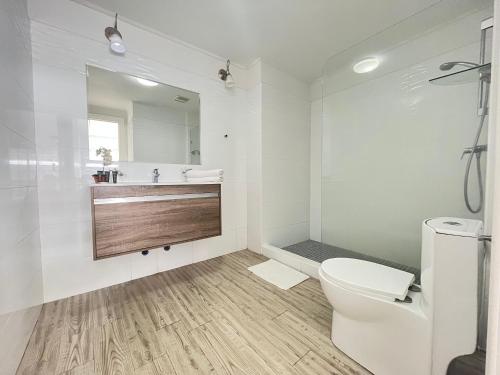 a white bathroom with a toilet and a sink at Boutique Apartments Panama Atlapa in Panama City