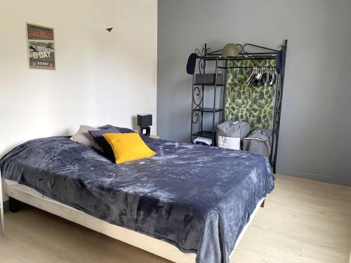 - une chambre avec un lit doté d'une couverture bleue dans l'établissement Le petit,gîte à 100m de la plage, à Asnelles