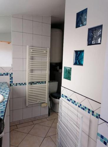 La salle de bains est pourvue de toilettes et de photos murales. dans l'établissement Le petit,gîte à 100m de la plage, à Asnelles