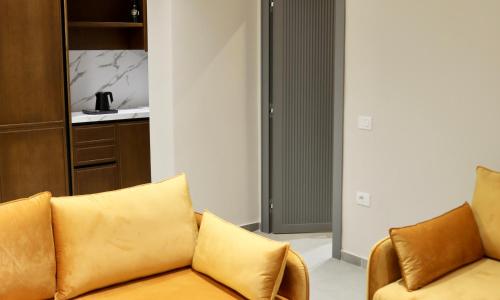 a living room with a couch and a kitchen at Anchor Luxury Rooms in Vlorë