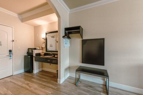 a bathroom with a sink and a desk in a room at Gateway Inn and Suites San Francisco SFO Airport in San Bruno
