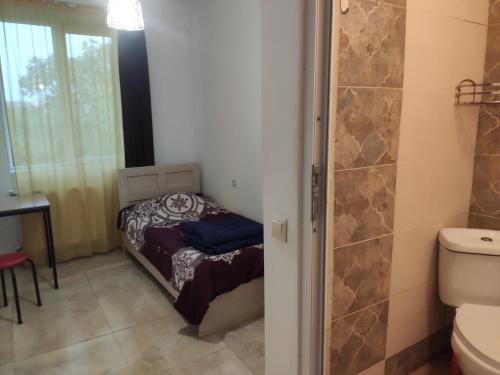 a small bathroom with a small bed and a shower at Wine Garden Apartment in Tbilisi City