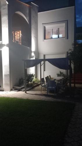 a house with a table and chairs in the yard at "Kochili Villa" LUXURY VILLA in Áyios Andréas