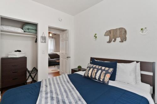 a bedroom with a bed with blue sheets and an elephant on the wall at 3 bedroom *Downtown* with Firepit in Colorado Springs