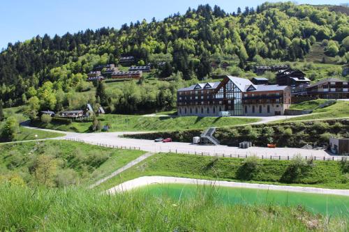 un grand bâtiment sur une colline à côté d'une rivière dans l'établissement Chalet montagne Pyrénées, à Ustou