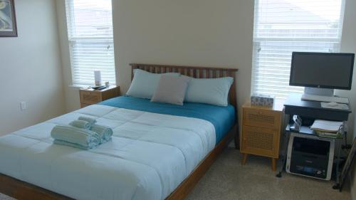 una camera da letto con un grande letto e una televisione di Stylish 3 Bedroom retreat near Downtown and Outlet a Kyle