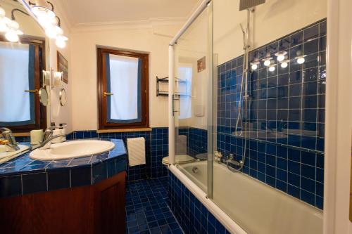 a blue tiled bathroom with a sink and a shower at Villa Aureliana with pool near San Peter in Rome