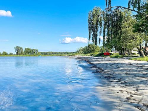 a beach with water and trees on the shore at 4 star holiday home in MÖRRUM in Mörrum