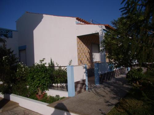 a white house with a fence in front of it at Casa da Amoreira in Luz de Tavira