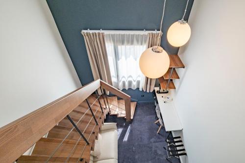 a staircase in a house with blue walls and two lights at Hôtel Le Relais des Brasseurs - Aubagne in Aubagne