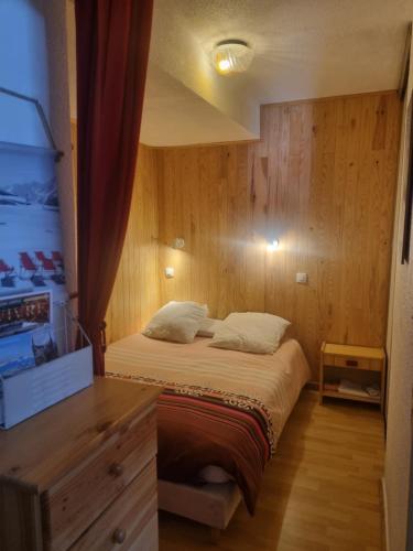 - une petite chambre avec un lit et une commode dans l'établissement Appart au pied des pistes - P2000, à Bolquère-Pyrénées 2000