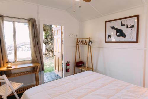 a bedroom with a bed and a large window at White’s Landing Catalina Camp in Avalon