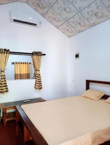 a bedroom with two beds and a ceiling with curtains at Turtle Island Cabana in Tangalle