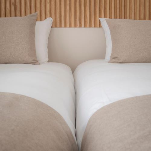 two beds with pillows sitting next to each other at Hôtel Le Relais des Brasseurs - Aubagne in Aubagne