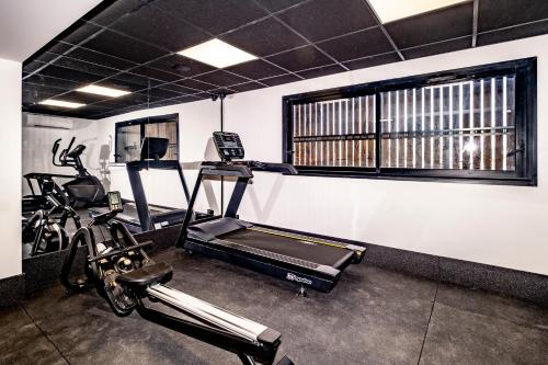 a gym with a treadmill and two exercise bikes at Hôtel Le Relais des Brasseurs - Aubagne in Aubagne