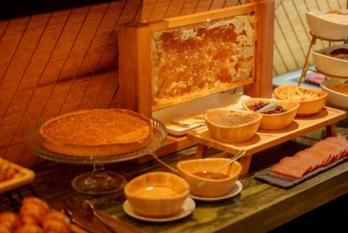 a buffet with pies and other food on a table at Hotel Nodo - El hotel que respira in Santiago