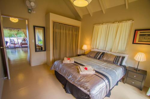 a bedroom with a bed with two towels on it at Cook Islands Holiday Villas - Muri Lagoon Beachfront in Rarotonga